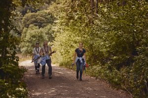 eine Gruppe junger Frauen wandert durch einen Wald.