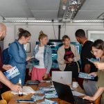 Viele Menschen stehen um einen Tisch, an dem sich ein Projekt vorstellt.